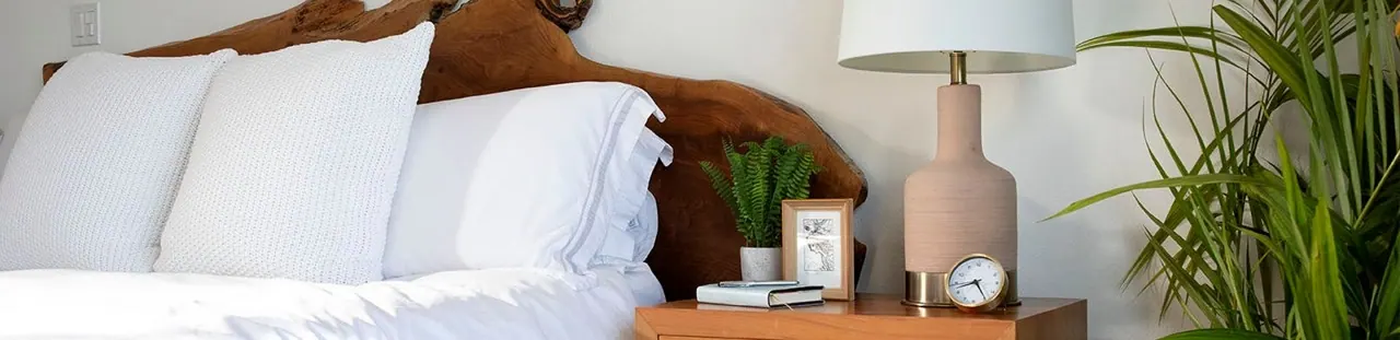 A made bed in a sunlit bedroom