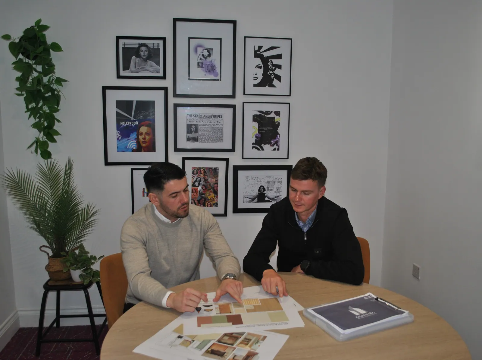 Two surveyors reviewing plans at a table